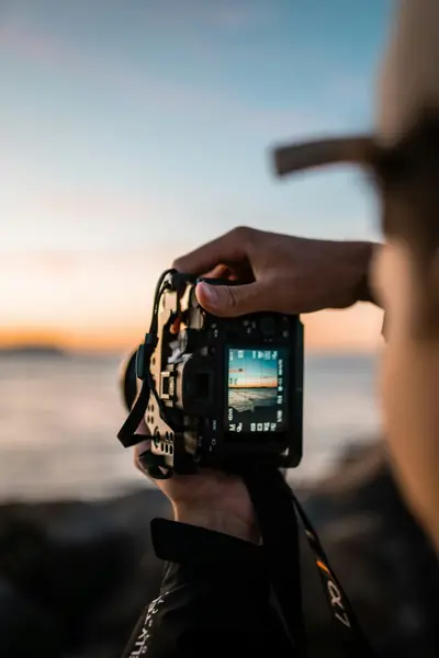 Pessoa fotografando o pôr do sol na praia